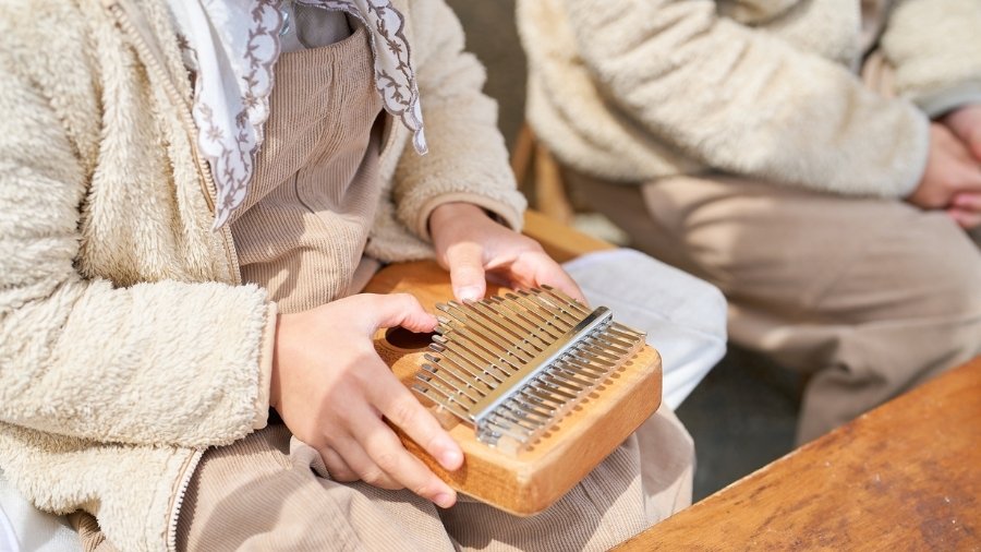 A kid beginner playing a kalimba
