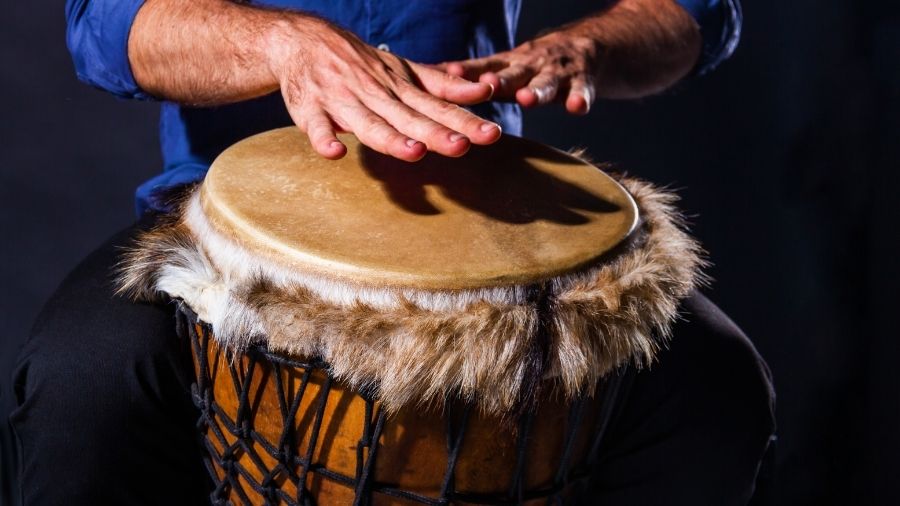 Closeup hands playing on djembe drum
