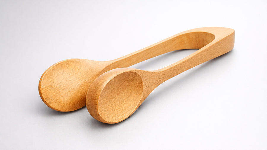 Handcrafted wooden spoon tongs on a warm grey satin background