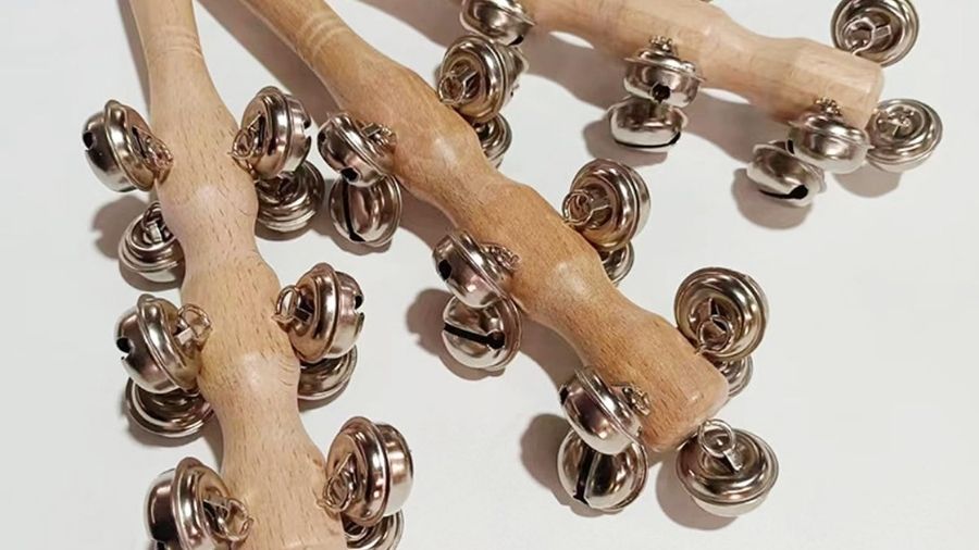 Handheld sleigh bells 3-bell jingle stick used as a shaker for music, dance, and holiday celebrations.