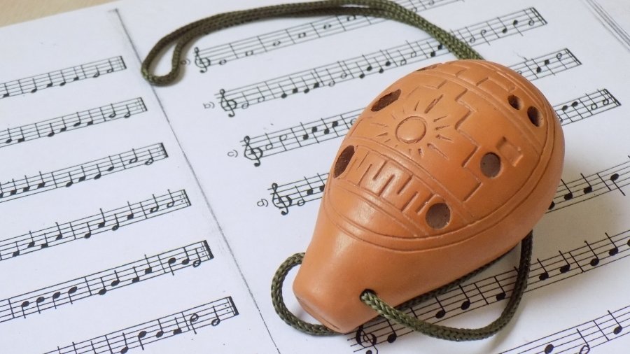 Brown Pendant Ocarina with a music sheet background