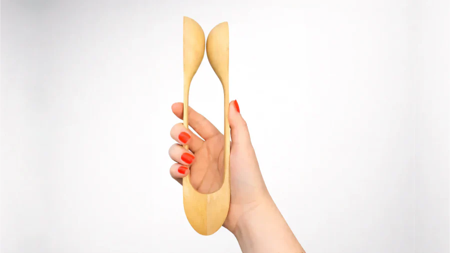 woman with red nails holding wooden musical spoons
