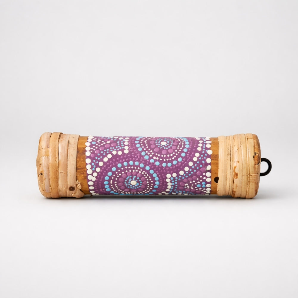 Purple dot painted pattern small bamboo rainstick Roll-up with bamboo base and purple on a white studio background