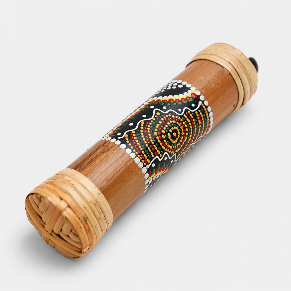 20cm rainstick made from nNatural bamboo with dot painted design inspired by Aboriginal art on a light gray studio background