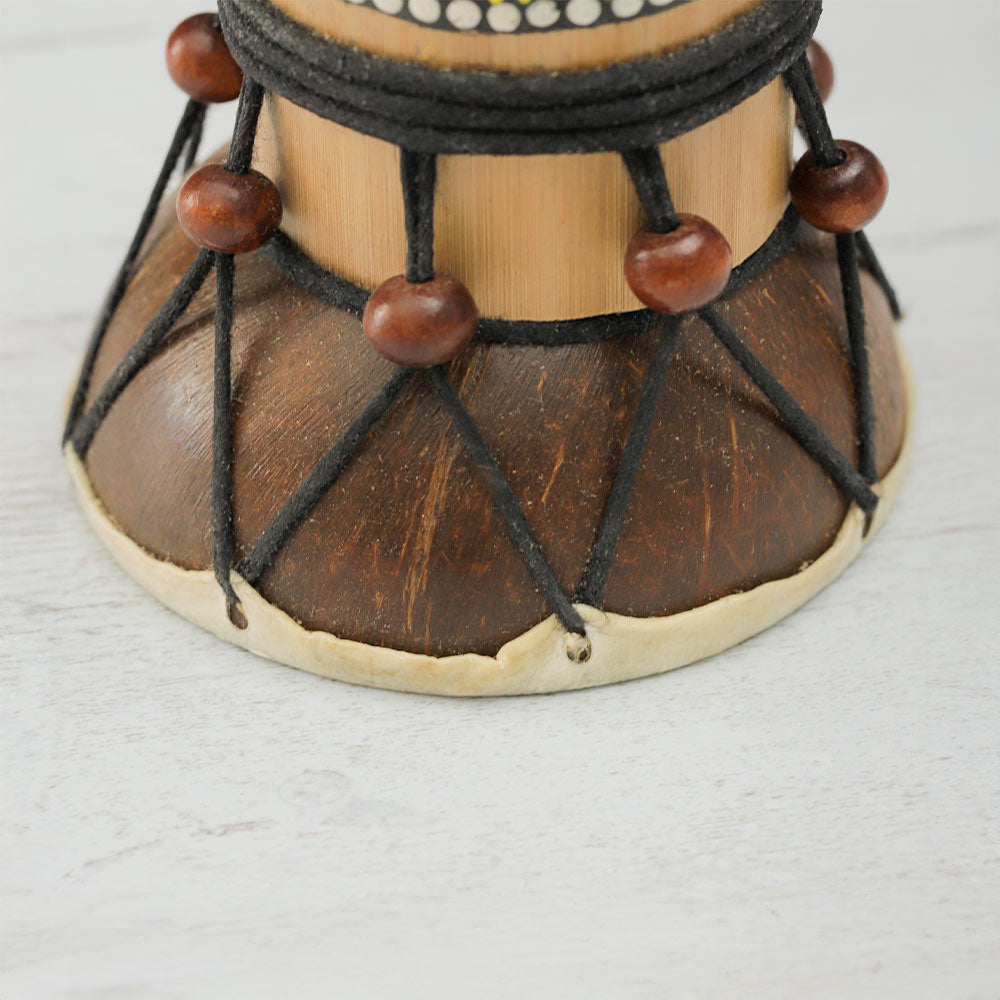 Close-up of the bottom part of the Begijen guitar, showing the coconut shell, rope ties, wooden beads, and bamboo frame.