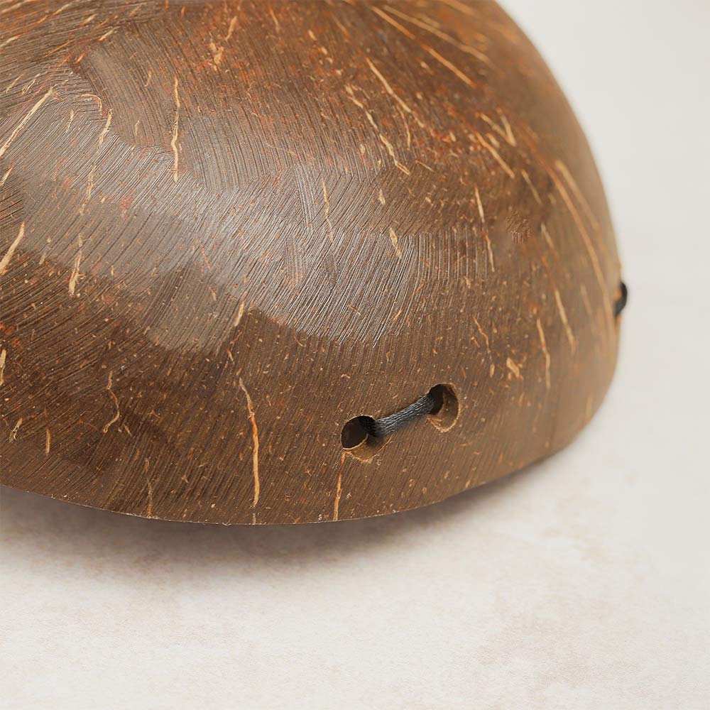 Close-up view of the bottom of a coconut husk tone block, showing the coconut shell bowl's texture and shape.