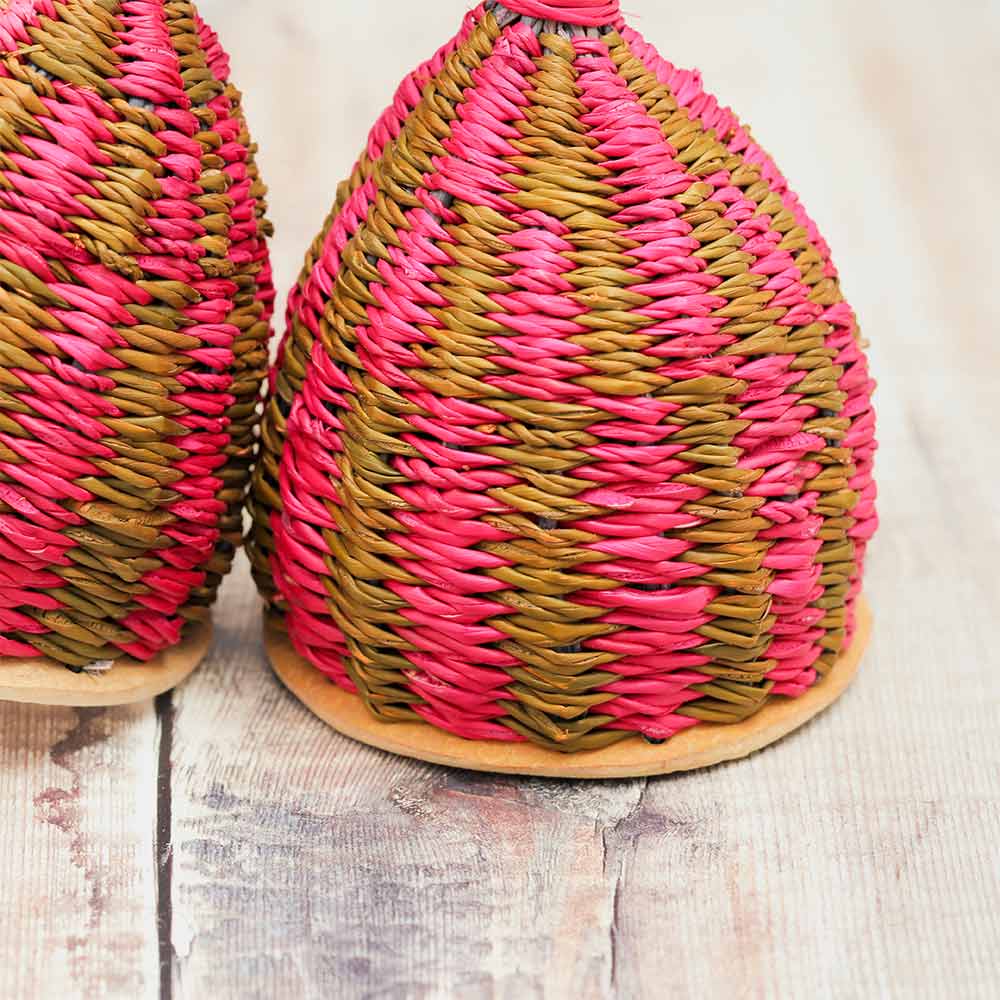 Close-up of the double caxixi shaker, highlighting the pink and brown straw details.