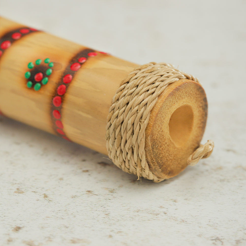 Close up of the Boing Stick showing the dot painted design, the bamboo structure and the rattan end
