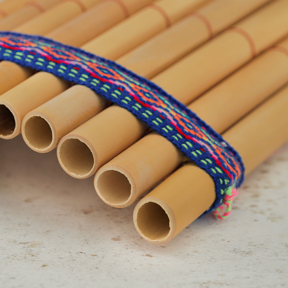 Close up of the top of the bamboo panpipes pan flute showing the holes for blowing and the woven band