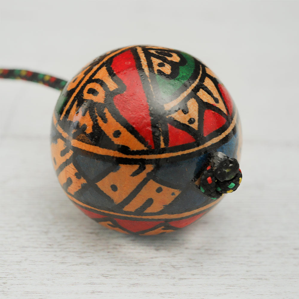 Close-up of a Geometric Kashaka shaker ball showing its abstract painted design in vibrant colors.