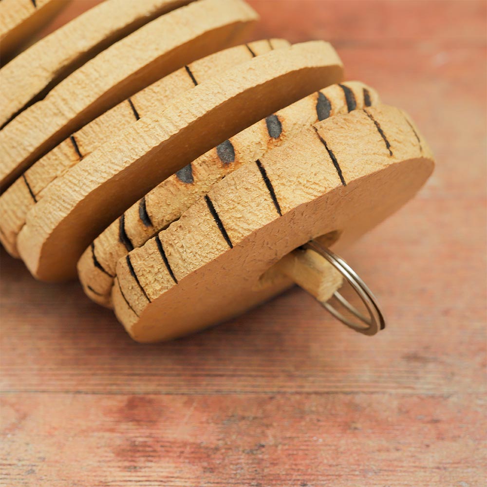 Close-up of the Gourd Rakatak showing the round percussive discs attached to the instrument, highlighting their natural texture and arrangement.