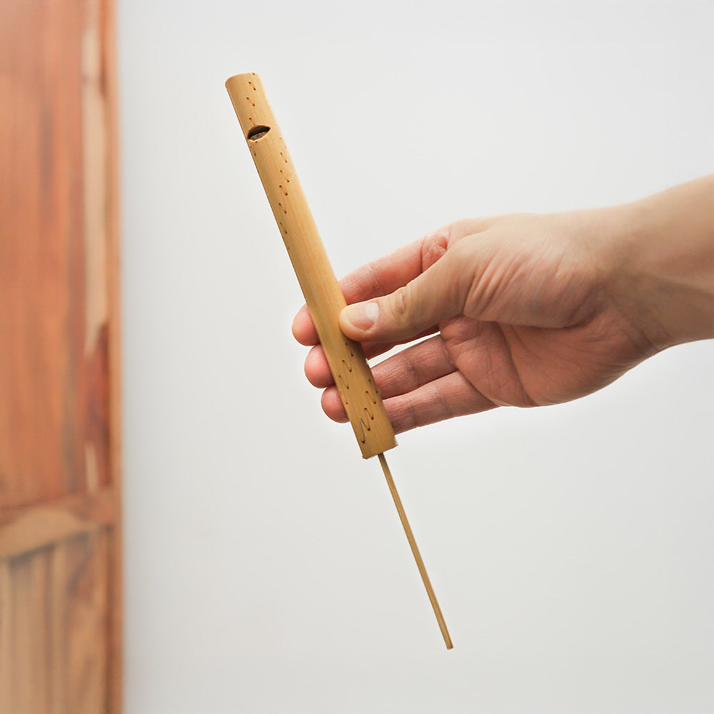 Indonesian bamboo whistle (large) held in hand, demonstrating its size and design.