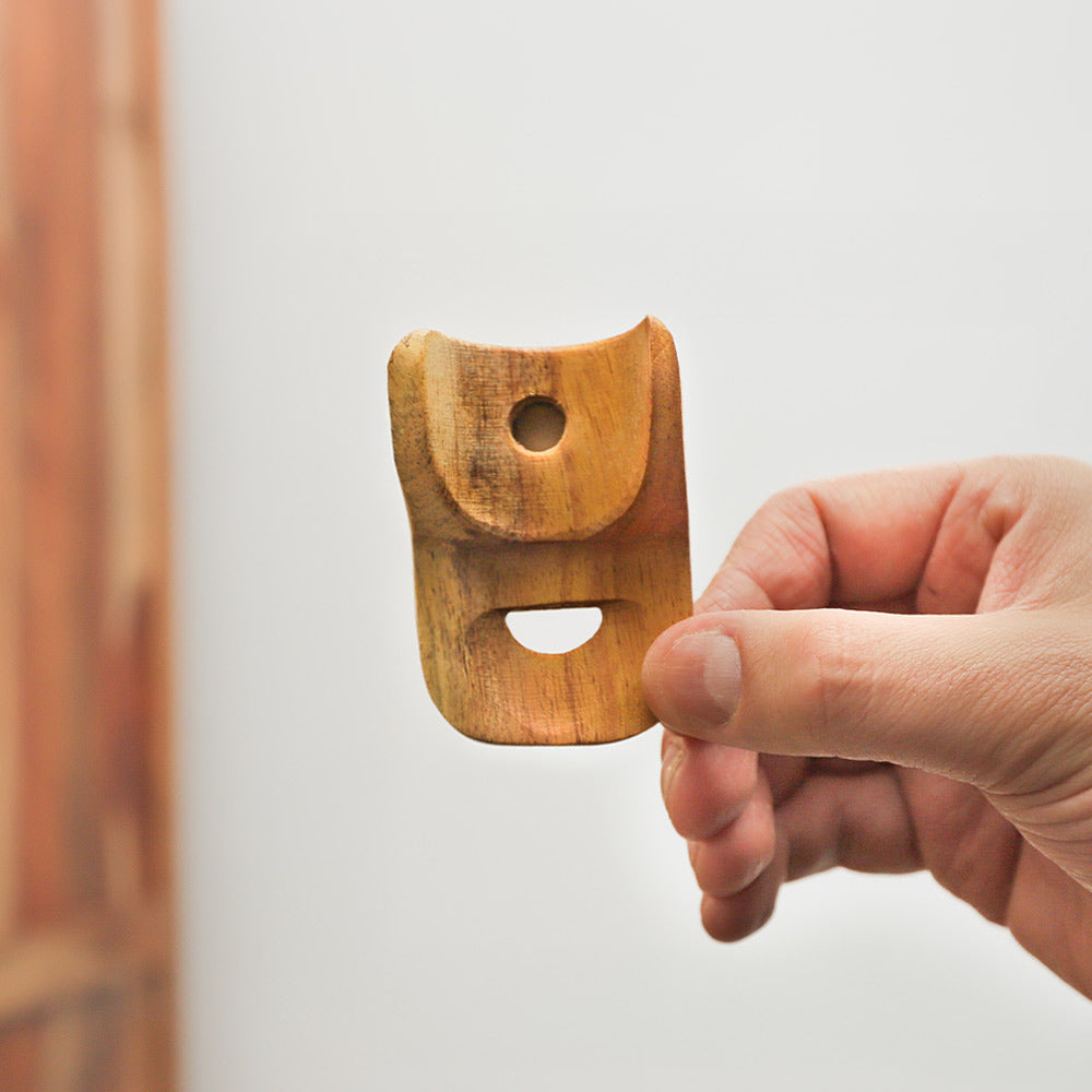 Jackfruit wood nose flute held in hand to show scale size and inside the flute.