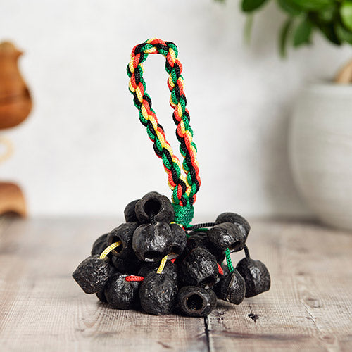 cluster of candle Kemiri nuts on vibrant Jamaican design handle