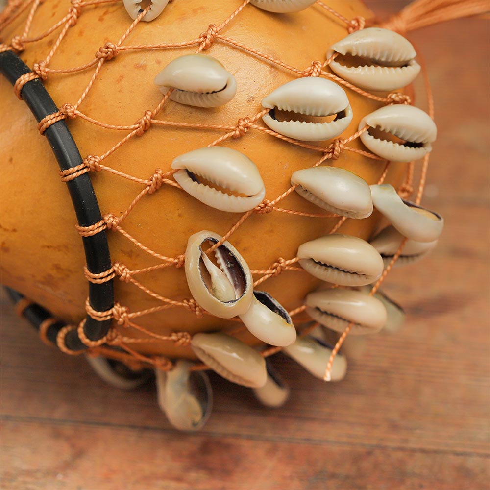 Close-up of the instrument head showing natural cowrie shells on the Kenyan Cowrie Calabash Shaker.