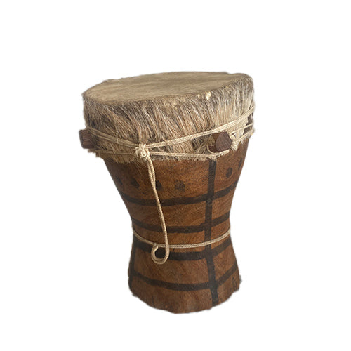 A traditional Kpanlogo drum made from goatskin and wood, with tribal decorations and a rope around the top edge.