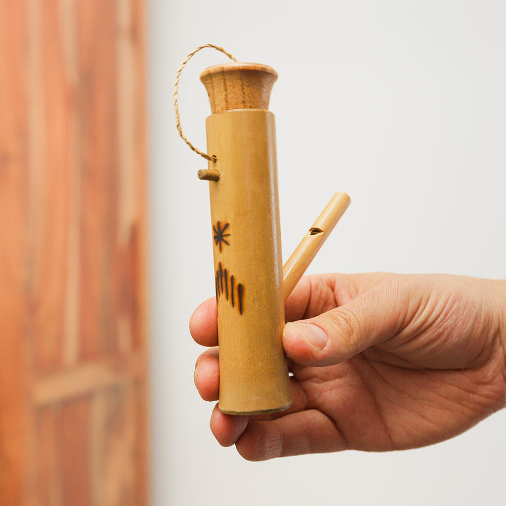 Kubu bird water whistle in hand, bamboo flute that mimics bird sounds when filled with water.