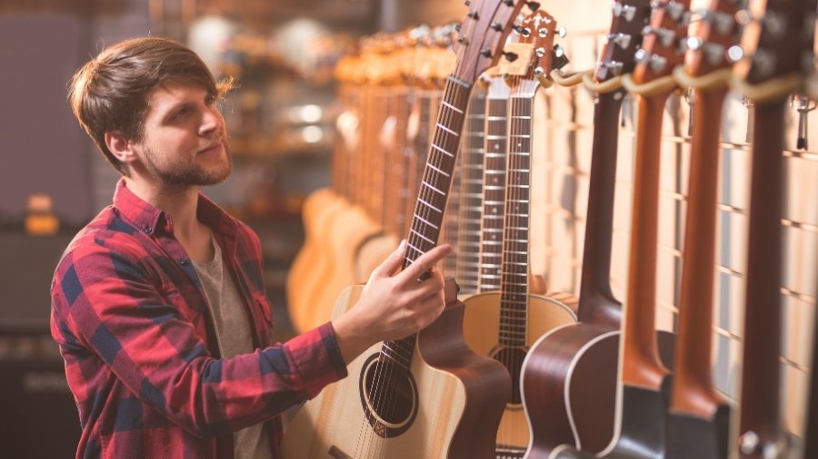 Man looking at a selection of guitars