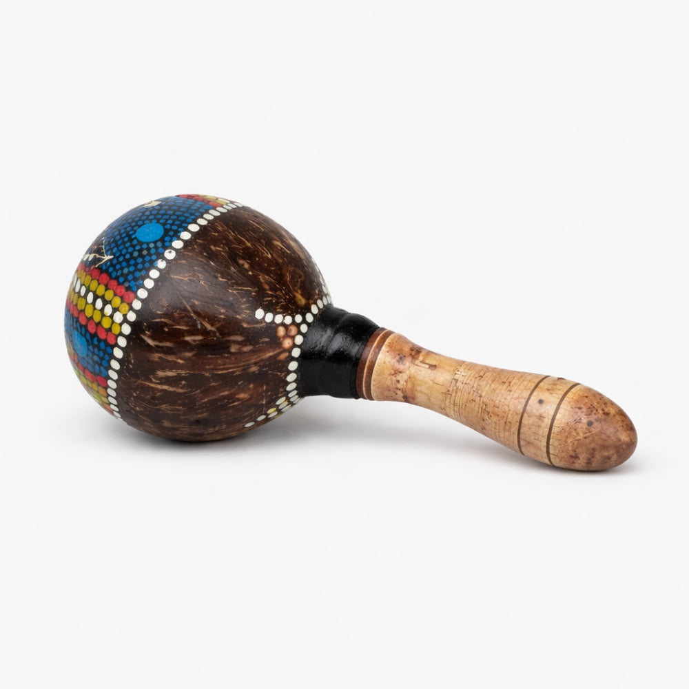 Hand painted colourful patterns on a coconut shell maraca with wooden handle on a white background