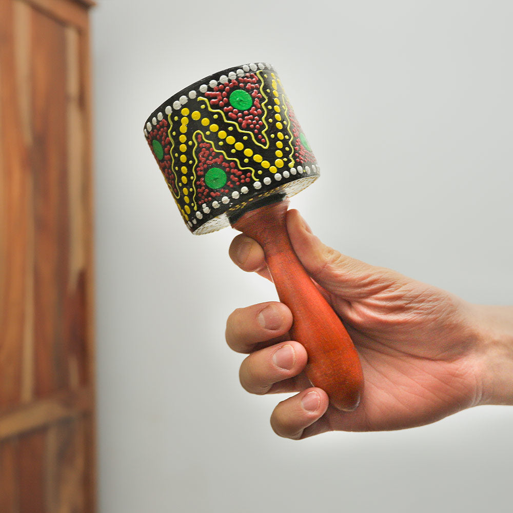 Penebel Barrel rattle shaker held in hand, demonstrating its size and distinctive shape.