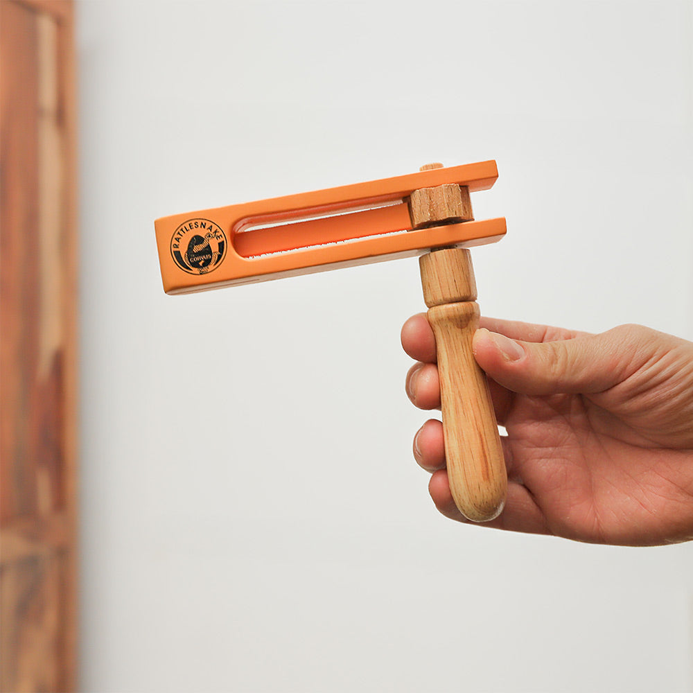 Wooden handheld Rattlesnake Percussion rattle ratchet, creating rhythmic clicks when spun.