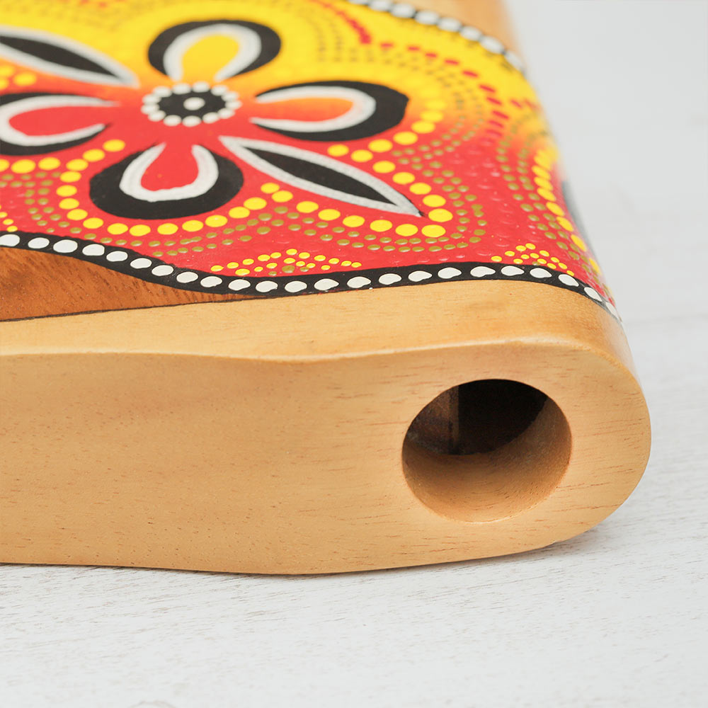 Close-up of the mouthpiece of a wooden hand-painted didgeridoo, showcasing its intricate design and smooth finish.