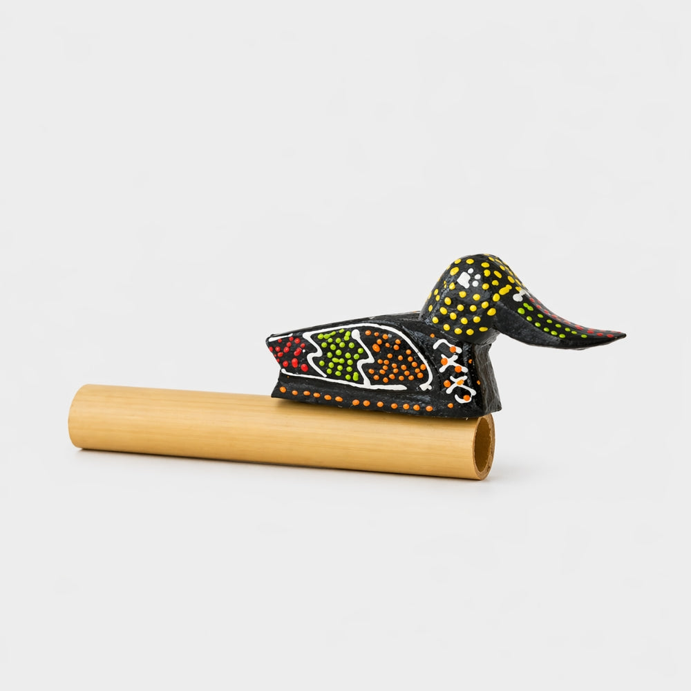 Decorative wooden duck quacker whistle with colourful patterns on a white studio background