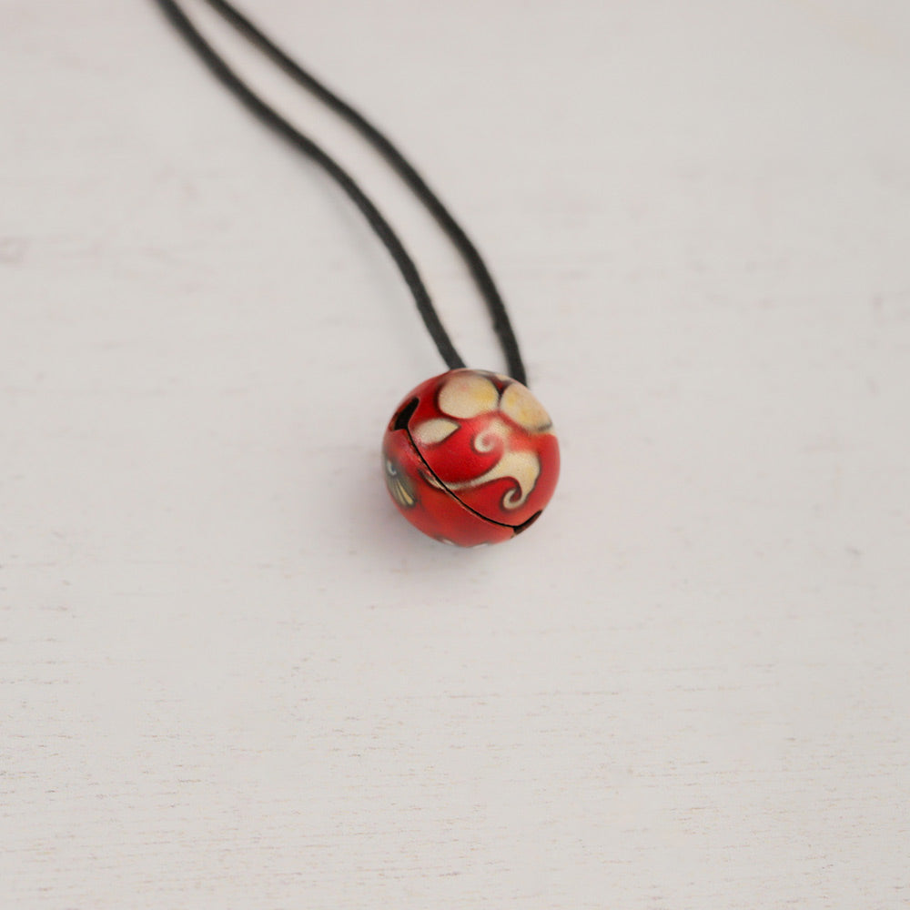 close up of red bell necklace