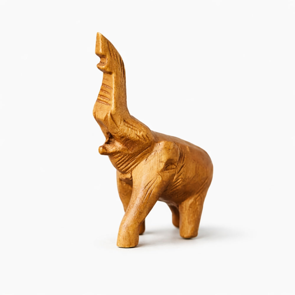 Carved solid wood elephant flute whistle figurine standing with trunk on a white background