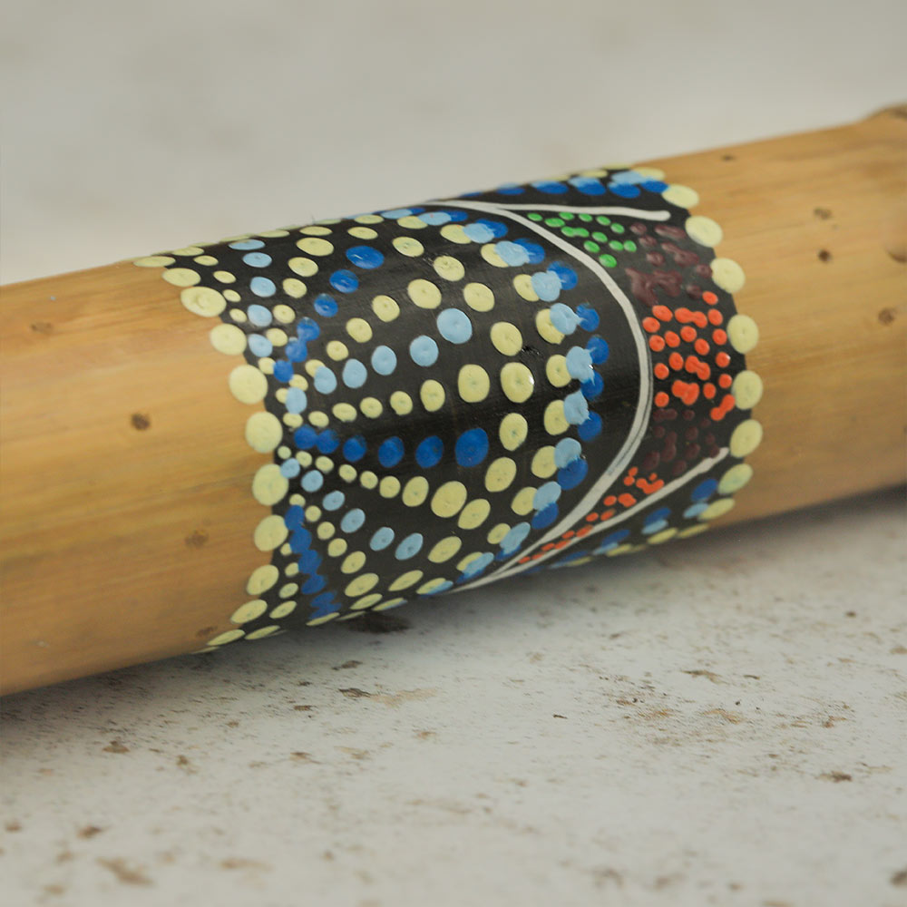 Close up of the dot painted design on the natural bamboo rainstick