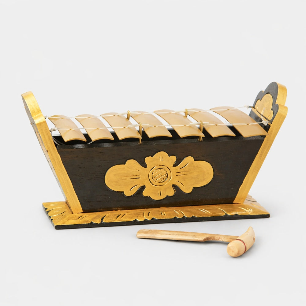 Wooden xylophone with decorative emblem and mallet on a white background