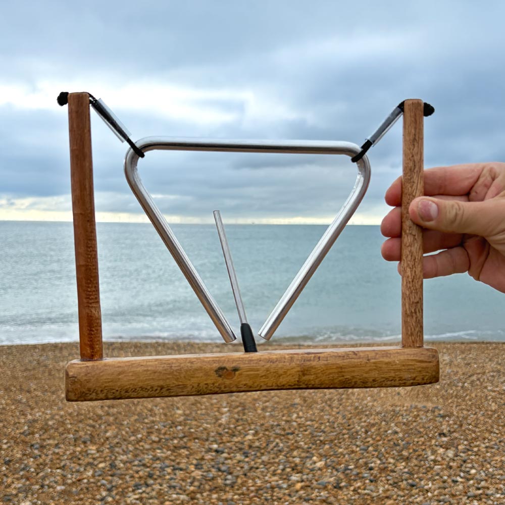 wooden stand with triangle in hand at the beach