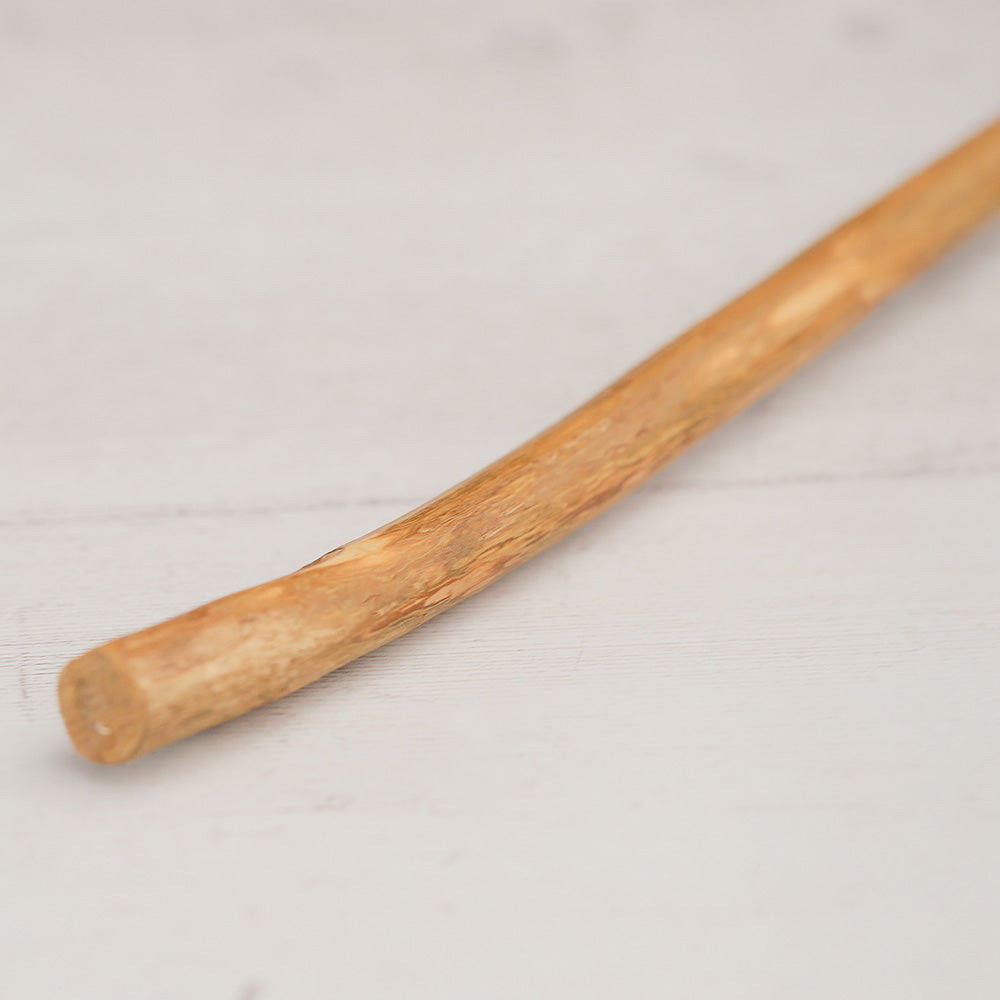 Wooden stick beater handle on a light gray background