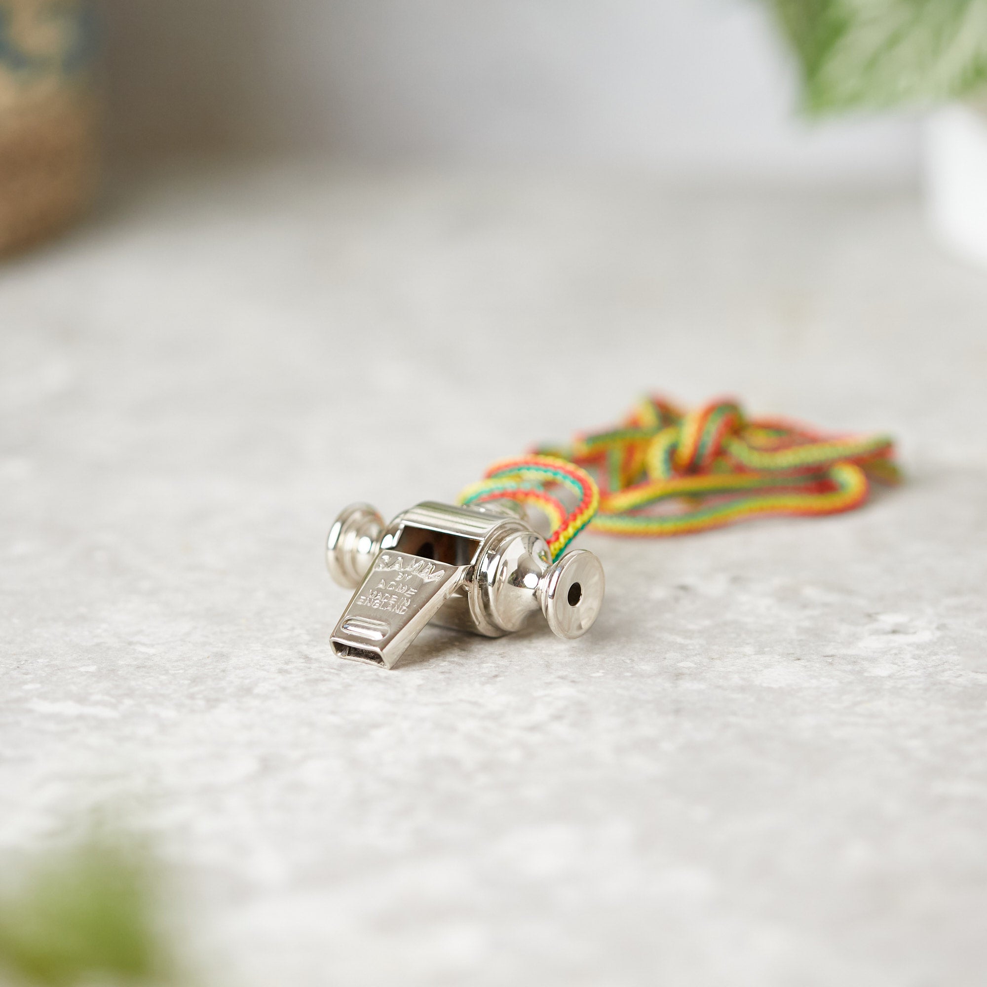 Stainless steel samba whistle with multicoloured cord, made in England