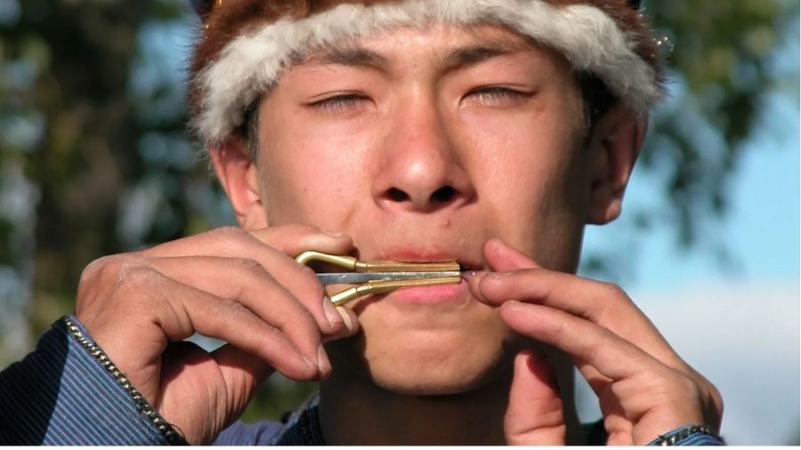 A man playing an ancient 1,700-year-old mouth harp, demonstrating that the historic instrument still produces a clear, resonant tune.
