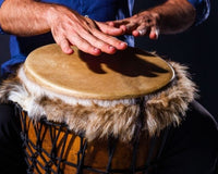 Closeup hands playing on djembe drum