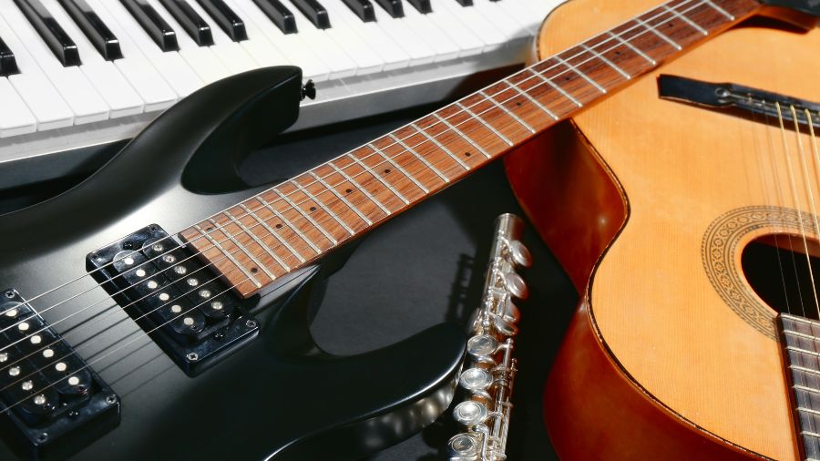 Selection of musical instruments including electric guitar, acoustic guitar, keyboard, and orchestral flute.