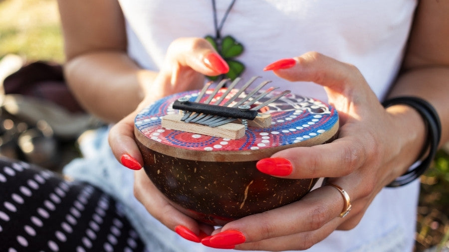 Woman playing a colorful coconut kalimba