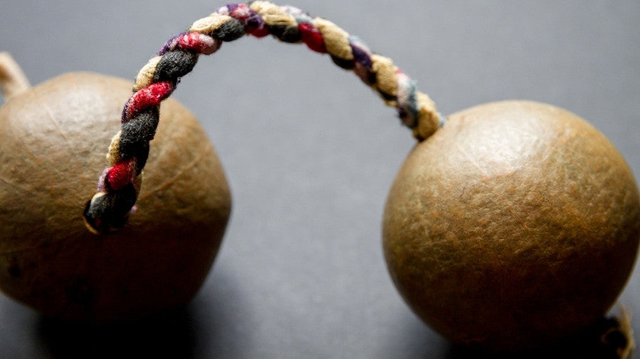 Close up of a single kashaka shaker on a dark background