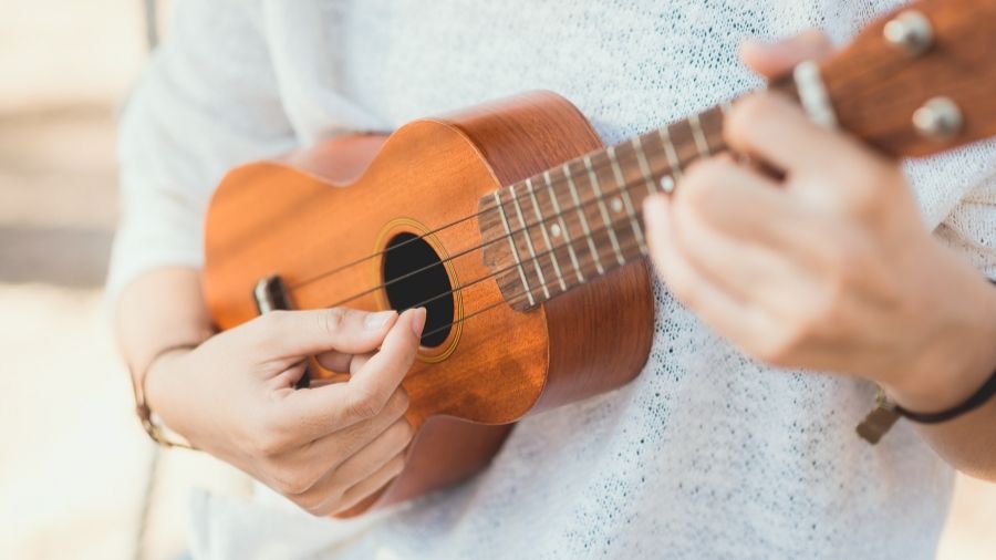 Young woman playing a ukulele.