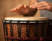 Mans hands about to slap djembe drum