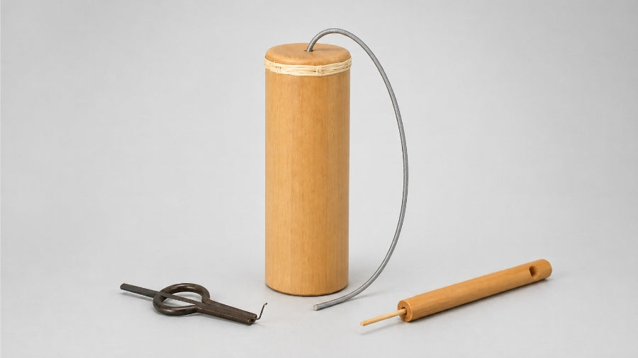 Bamboo thunder drum, cast iron jaw harp and indonesian slide whistle on light grey studio background
