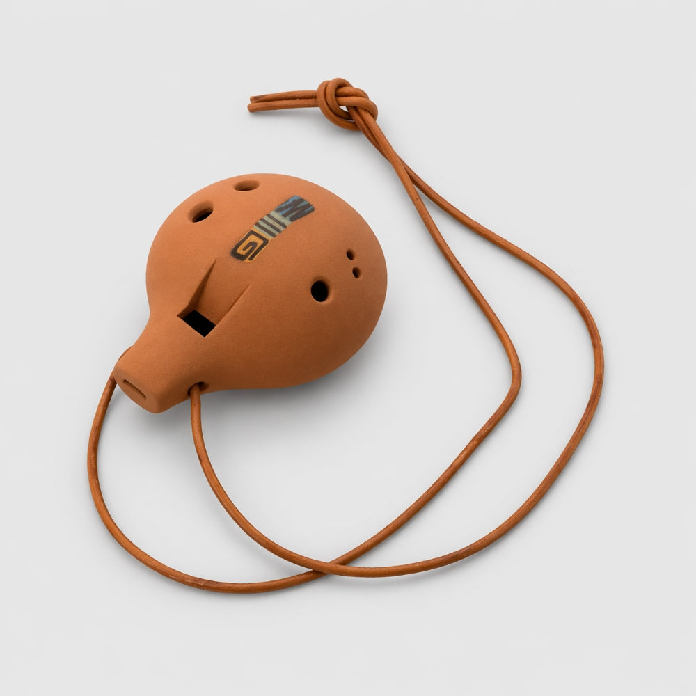 Brown clay ocarina with a brown tan leather string cord on a light gray studio background