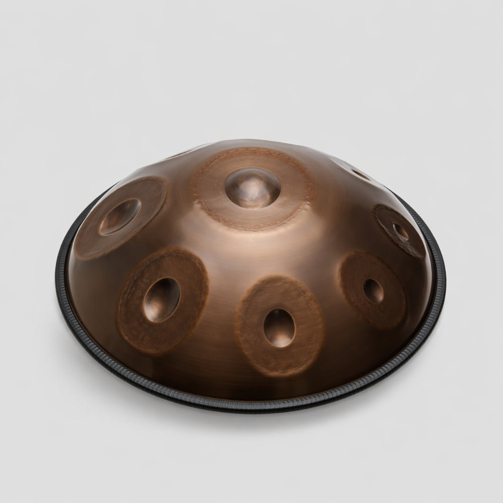 Brown nitrided steel handpan on a light gray studio background