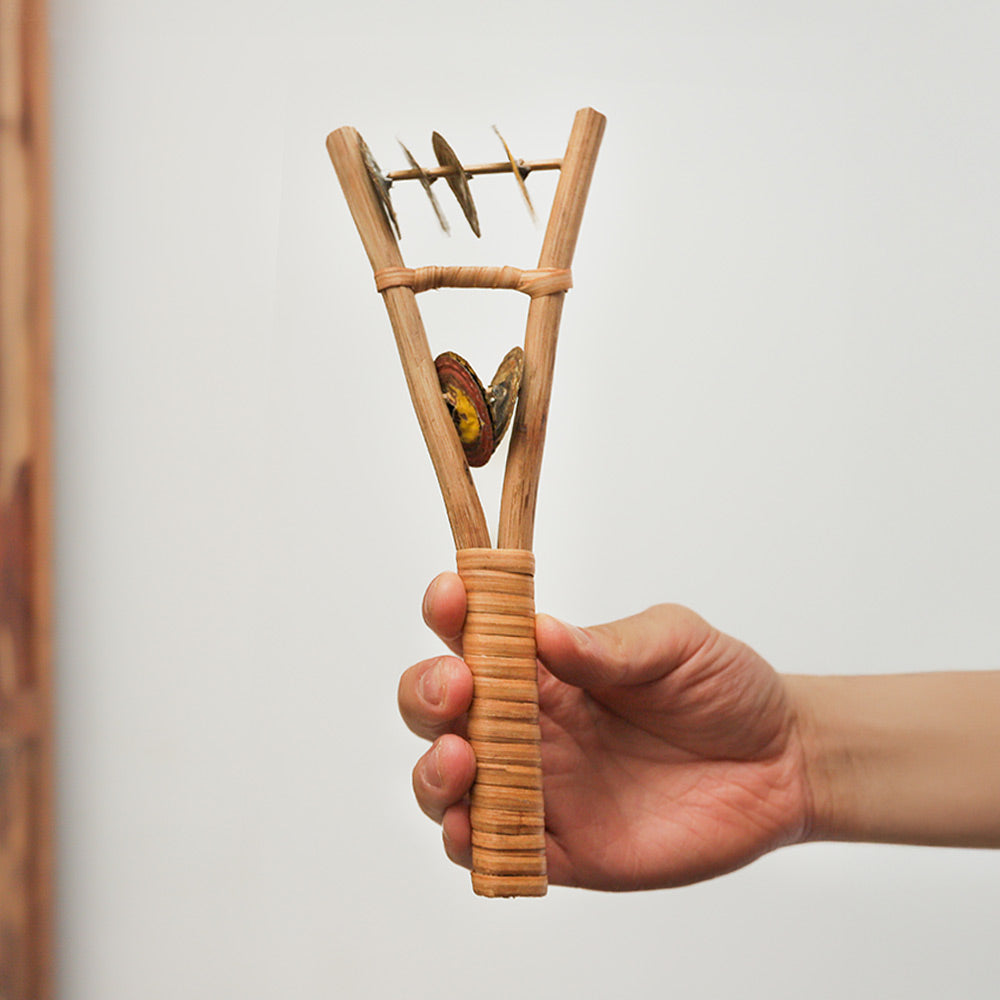 Handmade Katapot shaker from Ghana with a Y-shaped handle, crafted from flattened bottle caps. Creates lively rhythms, perfect for percussionists.
