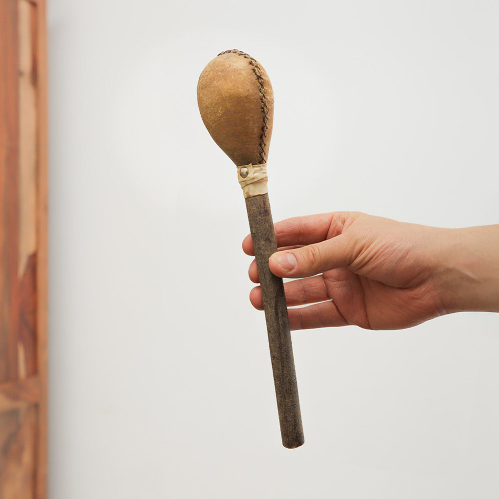 Handcrafted Khenji shamanic shaker from Pakistan, made with wood and cowhide. Produces warm, resonant tones for rituals and sound therapy.

