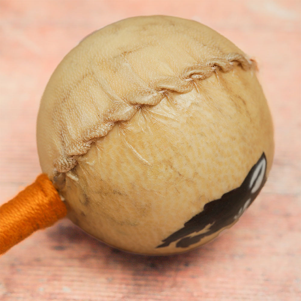 Close-up of the animal hide shaker head on its side, highlighting the visible stitching.