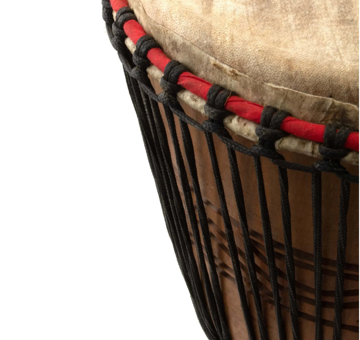 Close-up of a drum with red and black rope, on a white background
