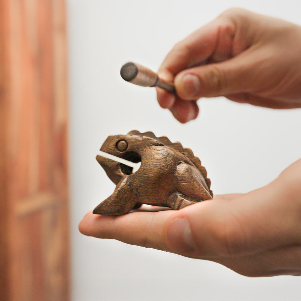Small croaking frog guiro held in hand to show scale size.