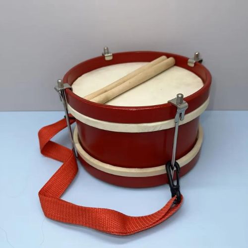 red and white marching drum with beaters